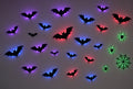 Mur avec chauves-souris noires rétroéclairées en violet, bleu et rouge, et araignées avec toile en vert